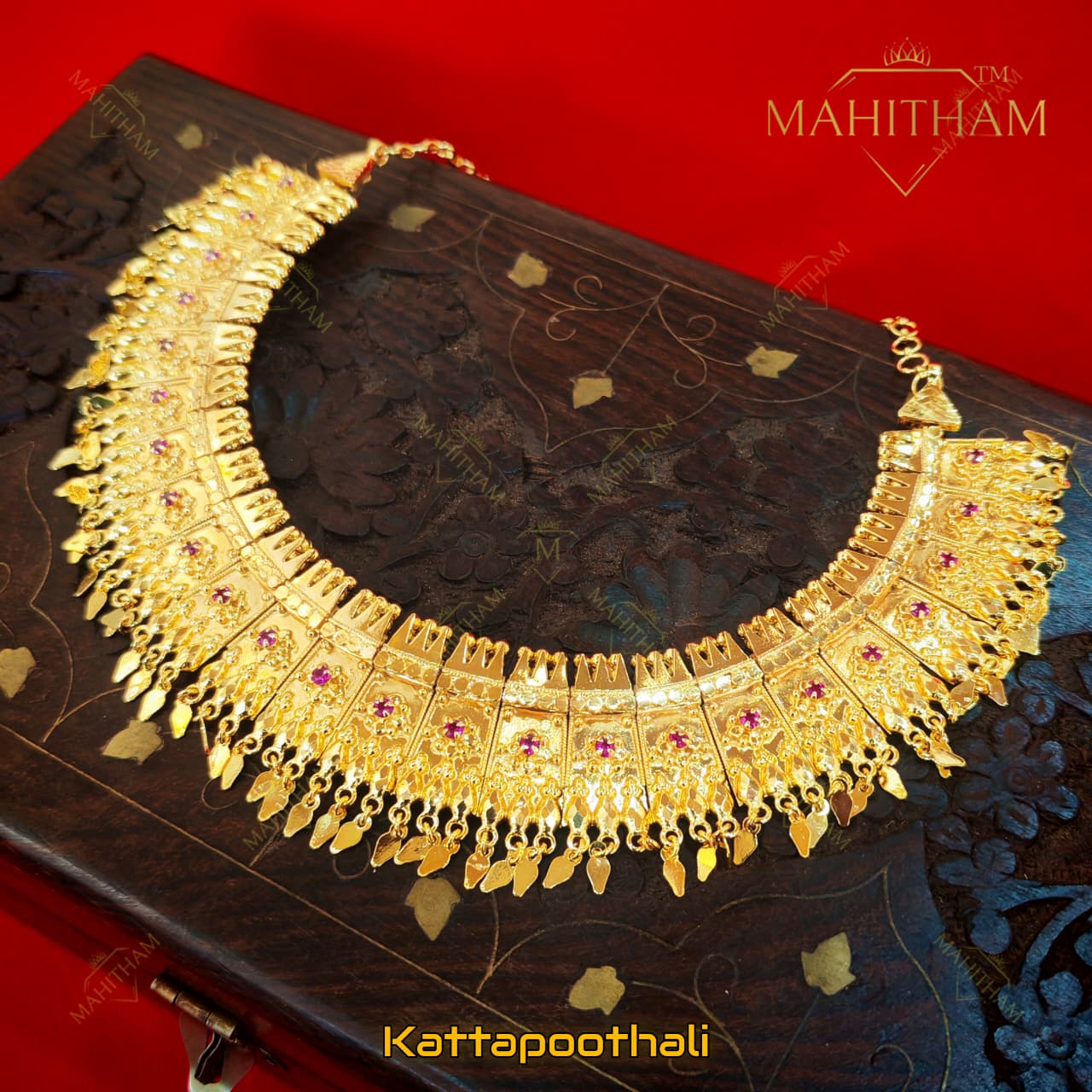 Mahitham Kattapoothali traditional necklace displayed in full with gold finish, ruby stone detailing and multiple hanging drops