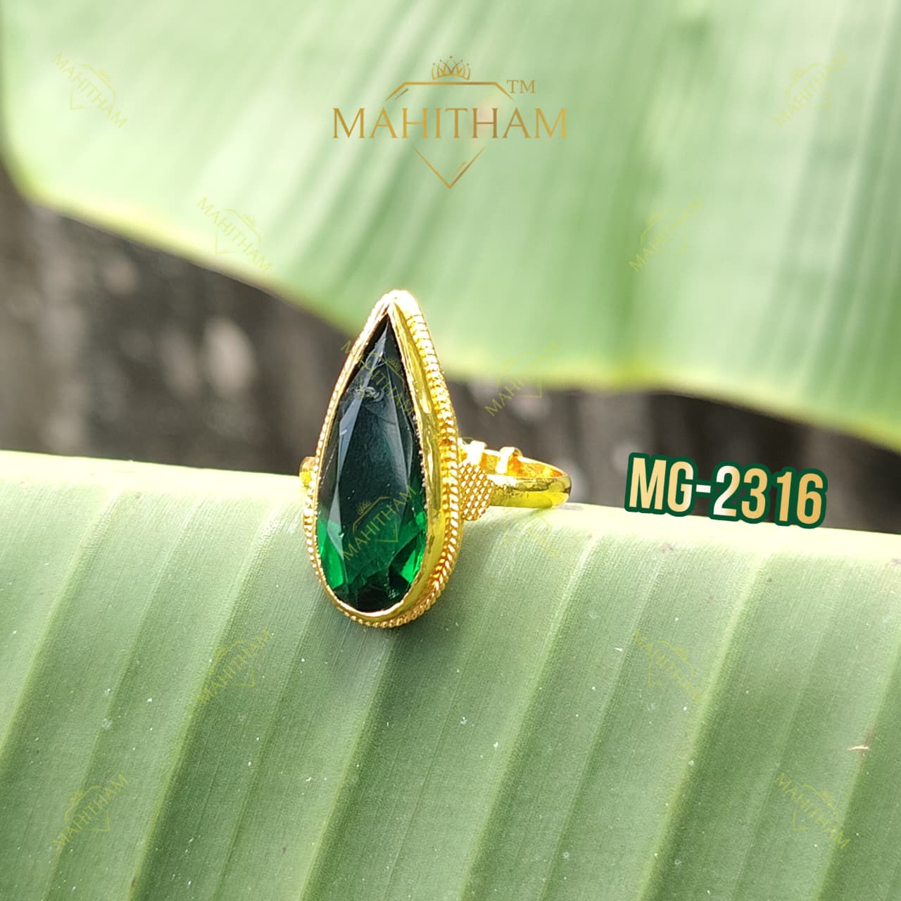Green Emerald Gopi Ring MG-2316 displayed on a green leaf with deep-green stone and traditional gold detailing