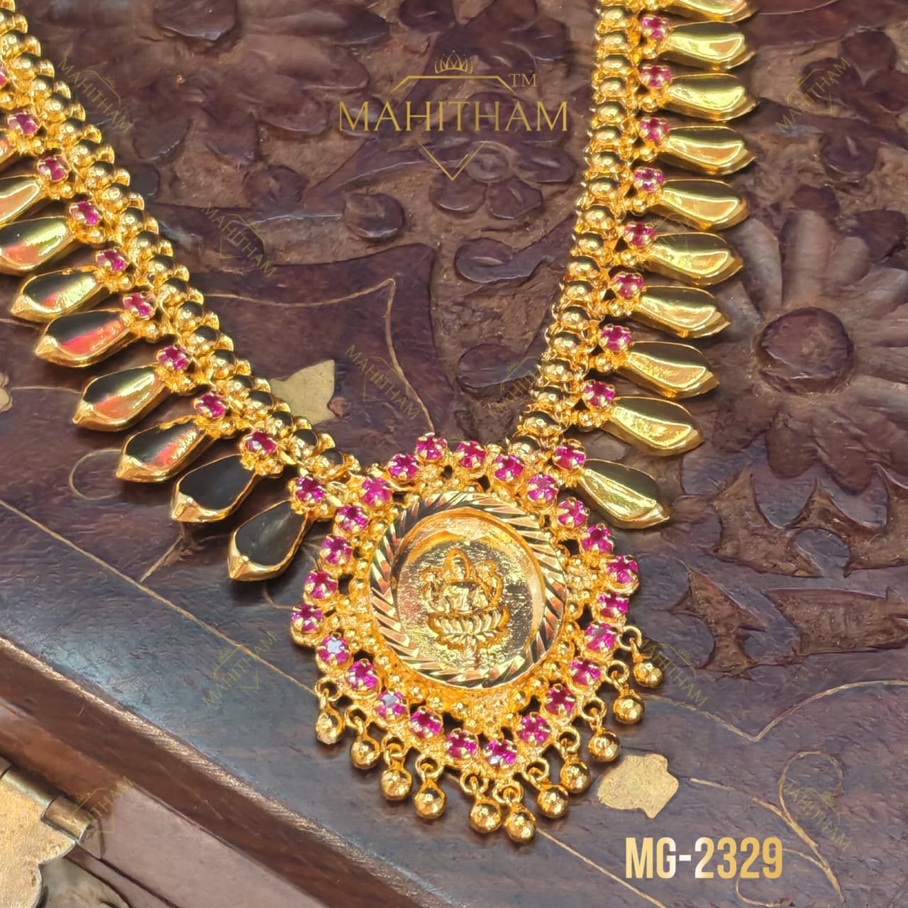 Close-up of Lakshmi motif pendant on Golden Nagapadam Necklace MG-2329 with ruby-pink stones and decorative gold hanging drops.